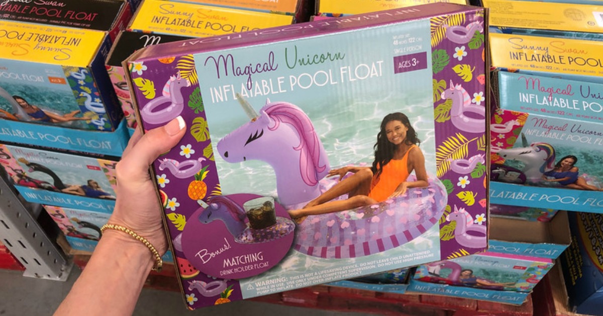 hand holding magical unicorn pool float box with floats displayed behind it