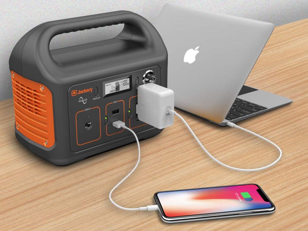 Macbook and iphone x being charged by Jackery Portable Power Station on table