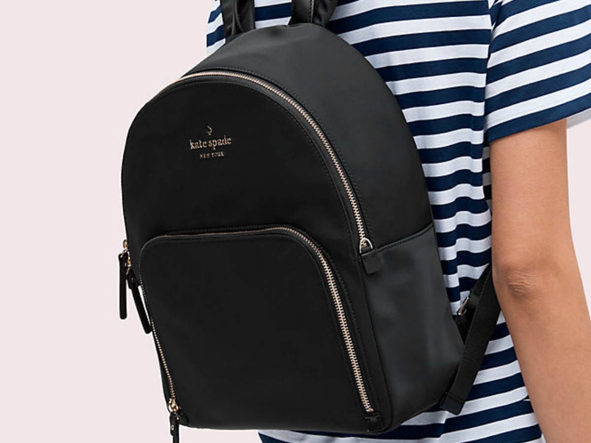 kate spade black backpack worn on young woman's back