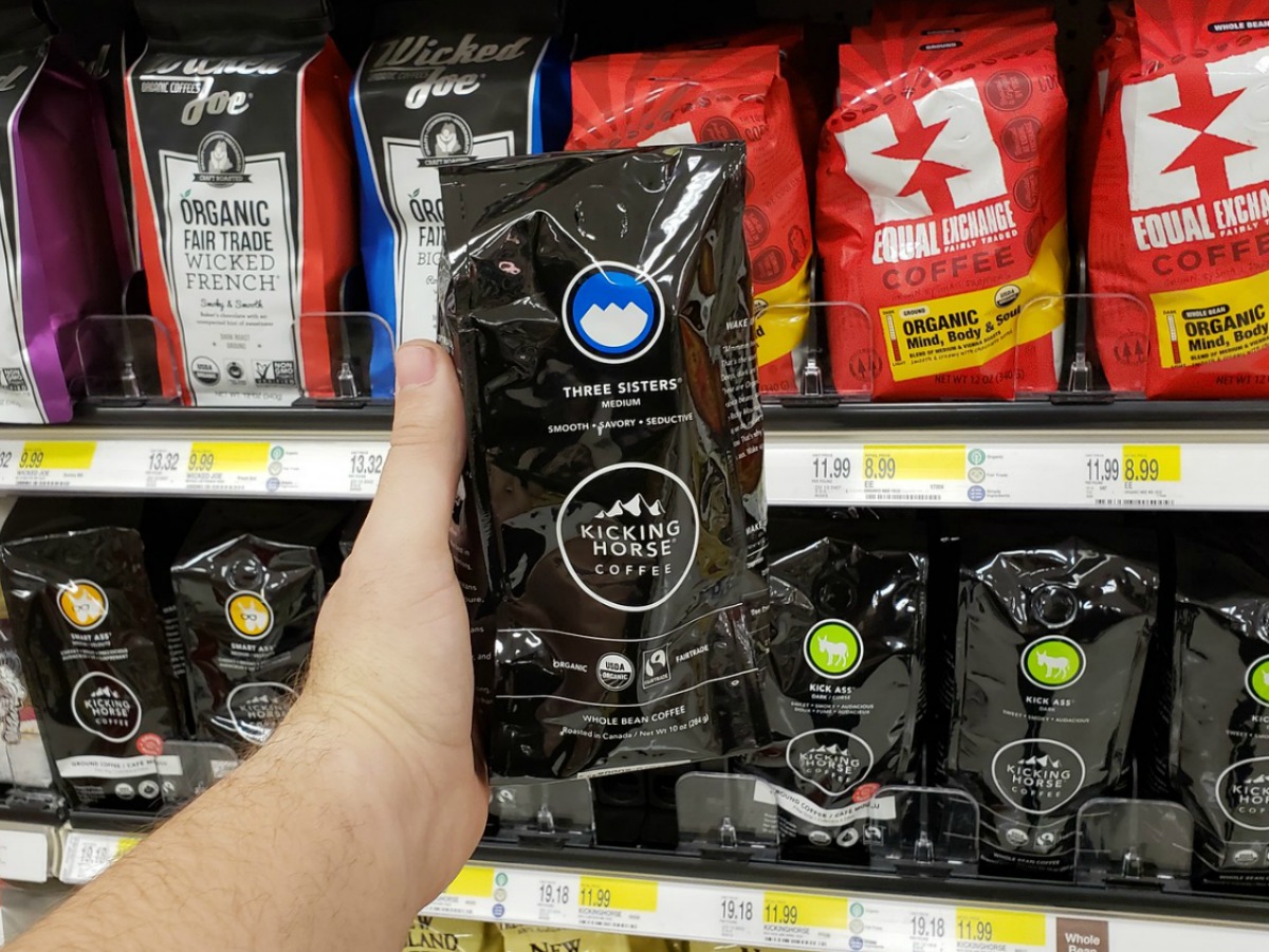 kicking horse bagged coffee being held in front of a shelf in a store