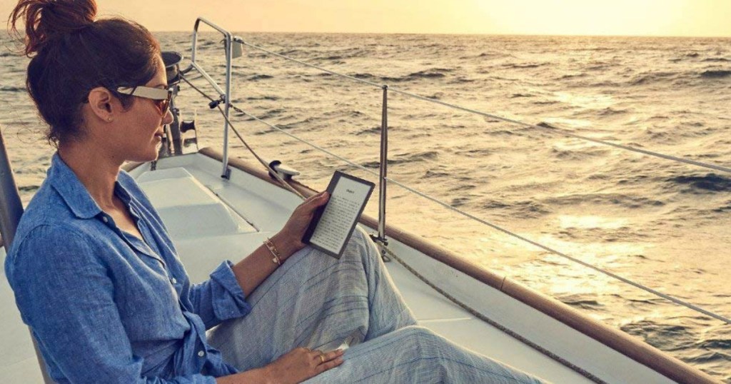woman holding Kindle Oasis sitting on boat