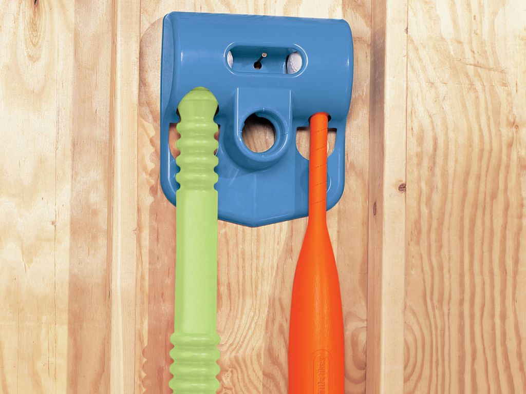blue, green, and orange Little Tikes TotSports T-Ball Set hanging on wooden wall