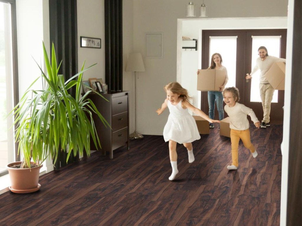 kids running inside with parents holding moving boxes on MSI Lowcountry Aged Walnut flooring