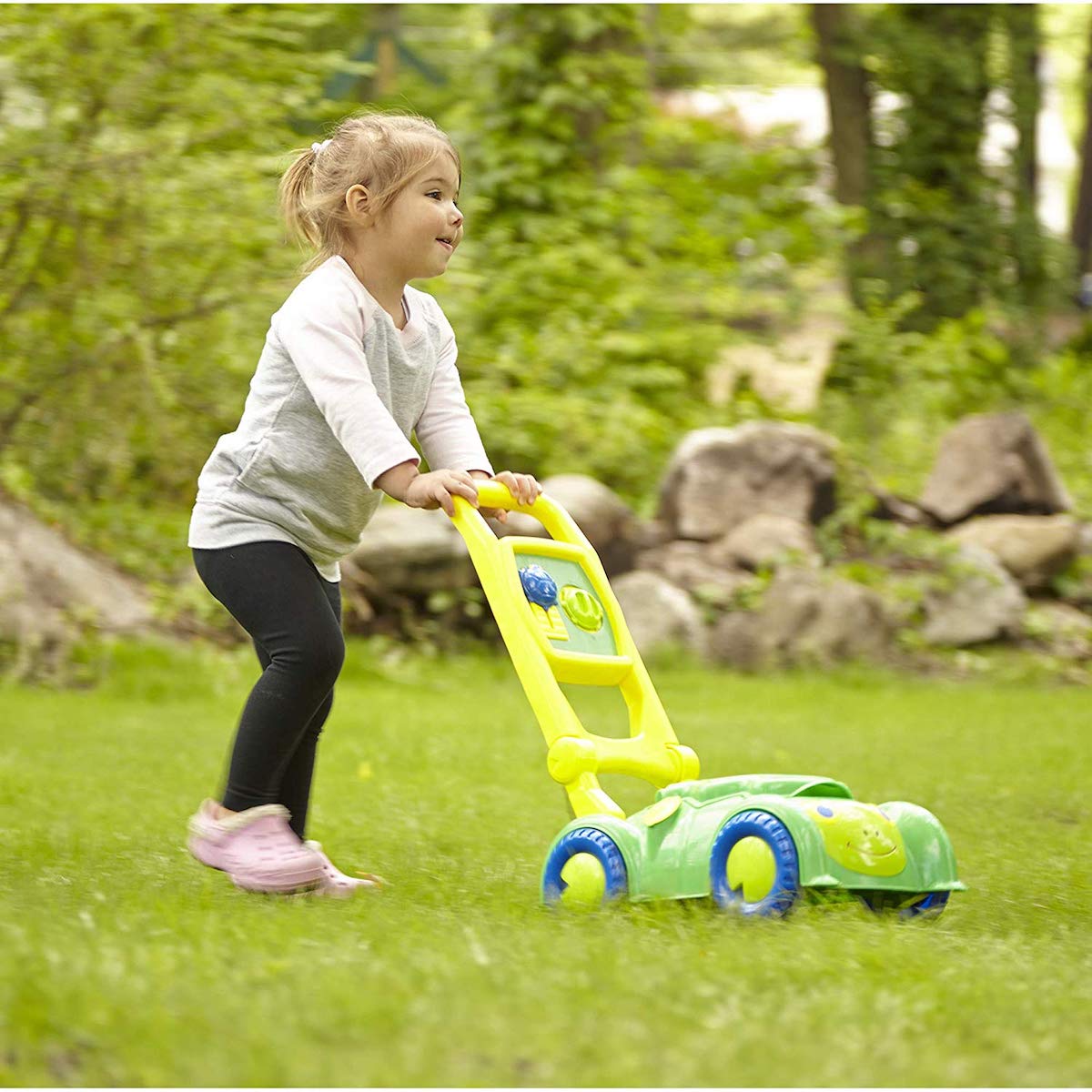 girl pushing Melissa & Doug Sunny Patch Snappy Turtle Mower in grass