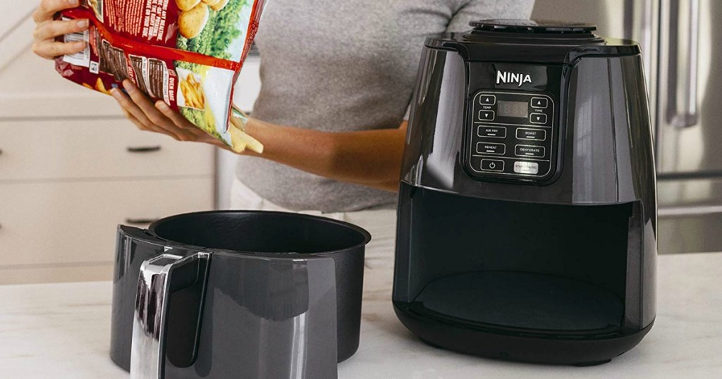 Ninjar 4 Quart Air Fryer with woman pouring french fries