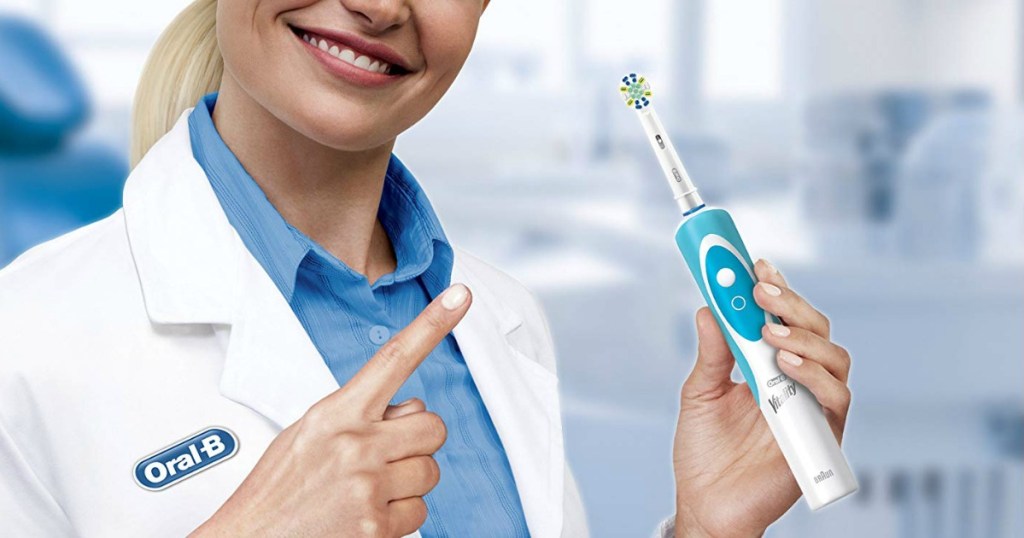 dentist holding Oral B electric toothbrush 