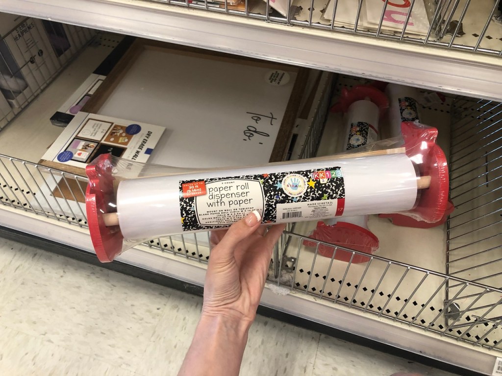 hand holding paper dispenser roll by store display