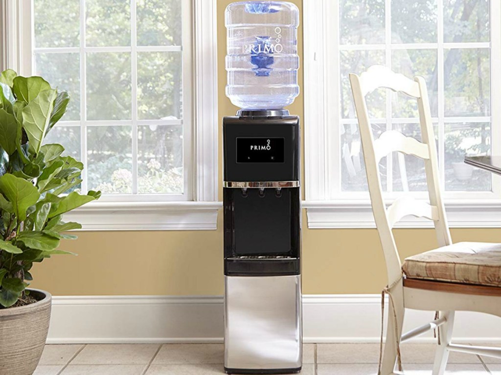 primo water dispenser placed in between two windows in a kitchen