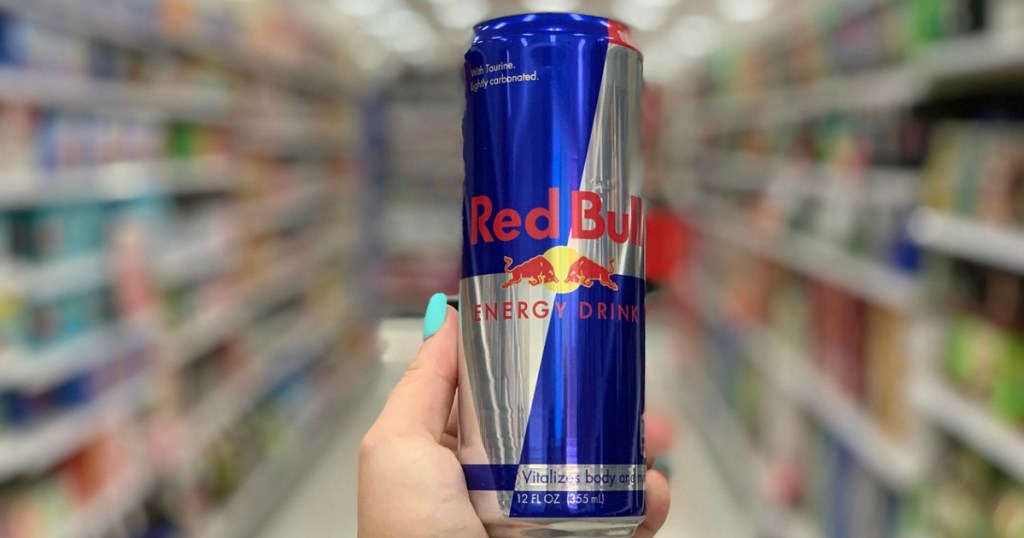 hand holding can of red bull in store