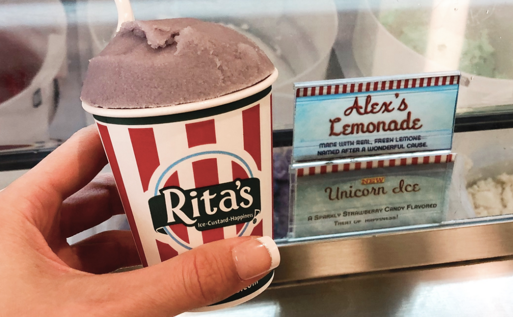 Rita's Unicorn Ice in front of ice cream freezer