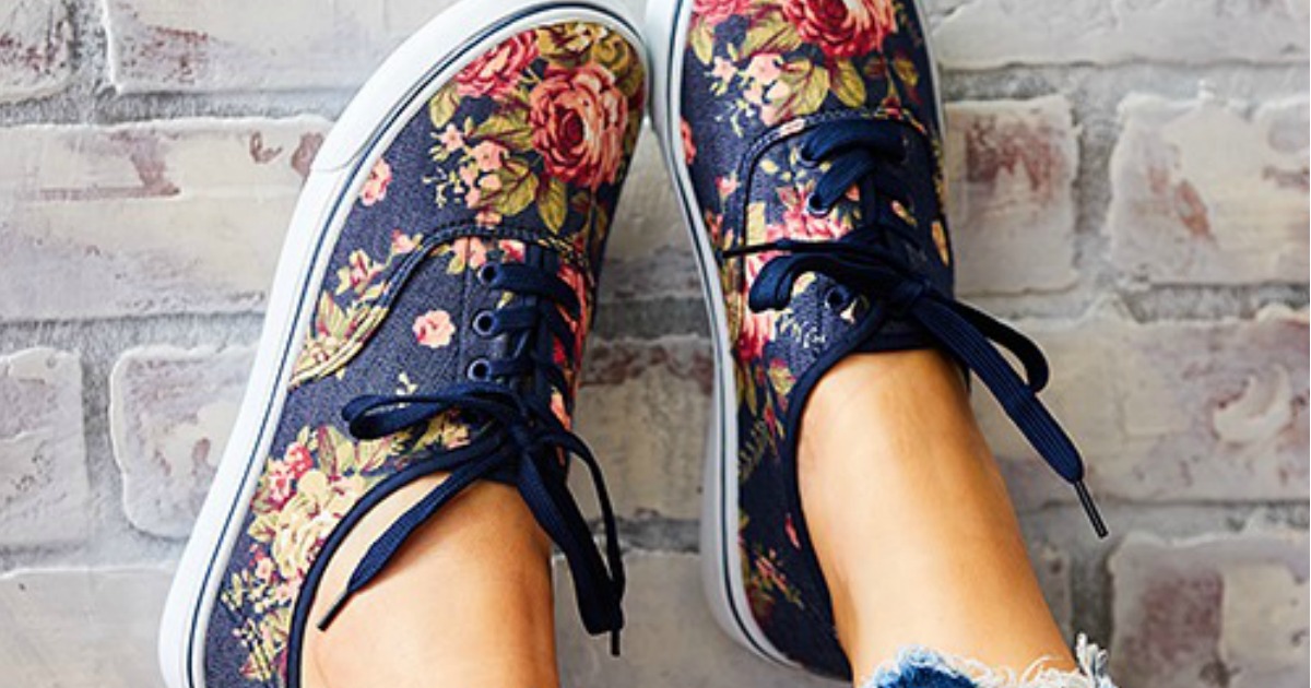 blue Rockland floral canvas shoes being worn with feet on wall