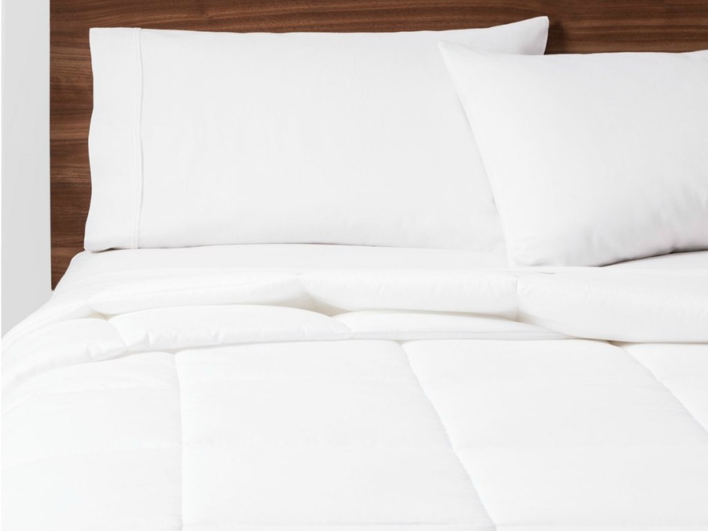 brown headboard white pillows and comforter on bed