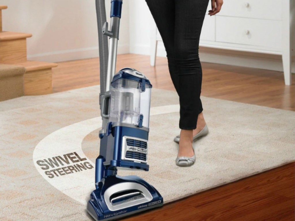 woman vacuuming rug on hardwood floor with shark liftaway navigator
