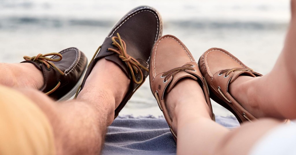 men and women laying on a beach blanket wearing boat shoes