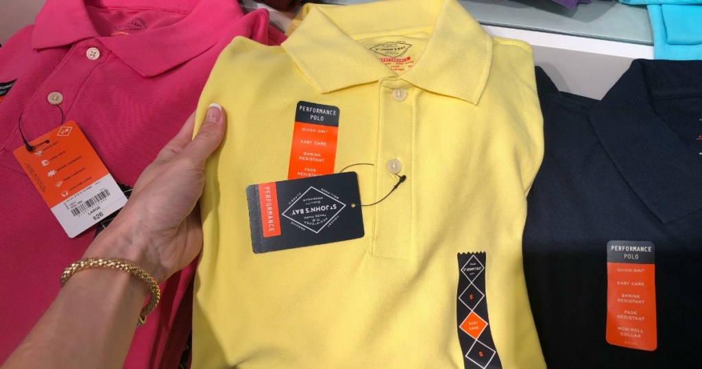 pink, yellow, and blue polo shirts being held against a store table