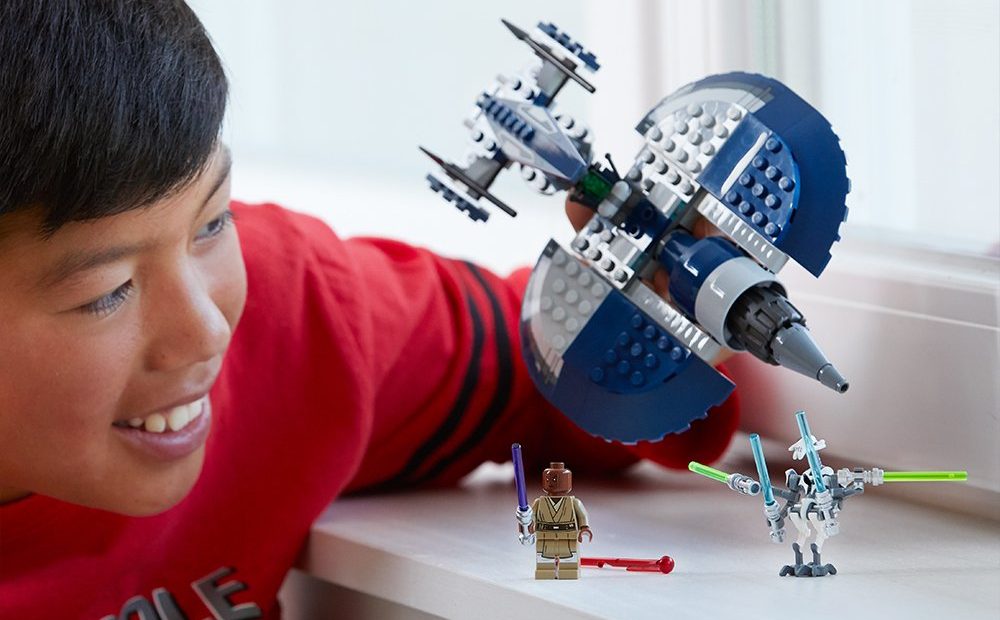boy playing with Star Wars LEGO set