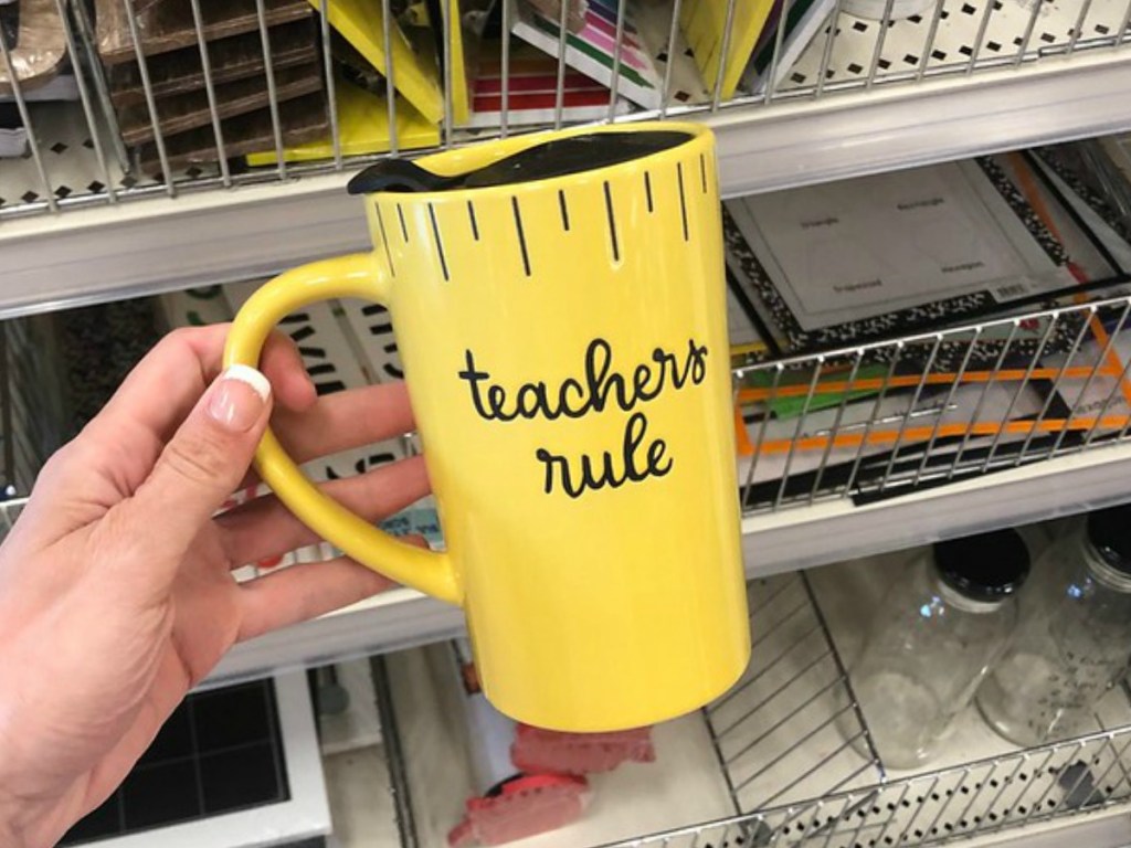 hand holding bright yellow mug by store display