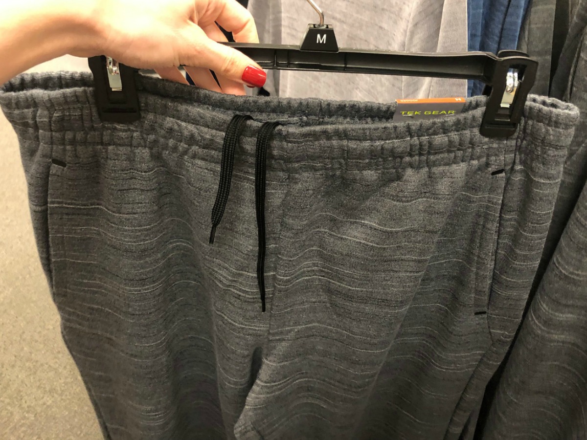 dark gray jogger pants on hanger being held on display