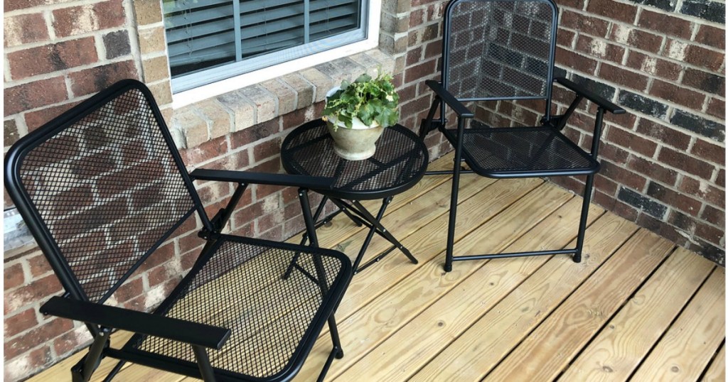 Metal folding patio table and chairs on a deck