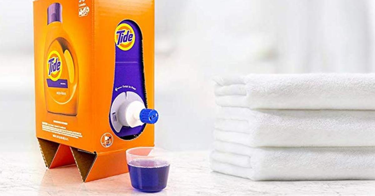 Tide Eco Friendly liquid laundry detergent Box dispensing detergent next to a stack of towels