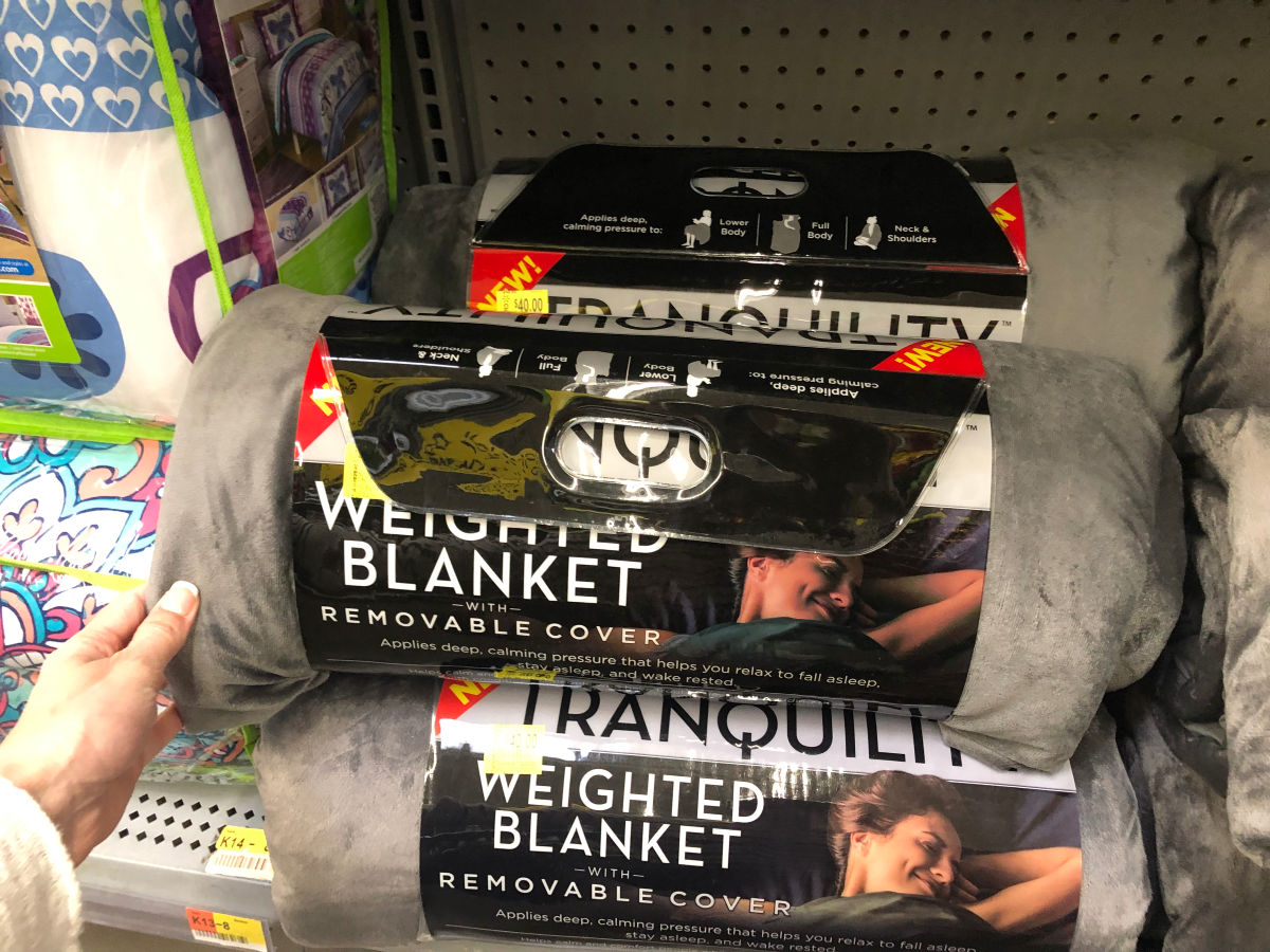 Person touching a Tranquility Weighted Blanket at Walmart 