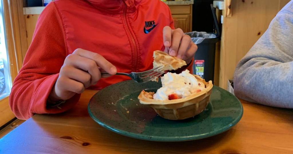 boy eating ice cream sundae out of waffle bowl