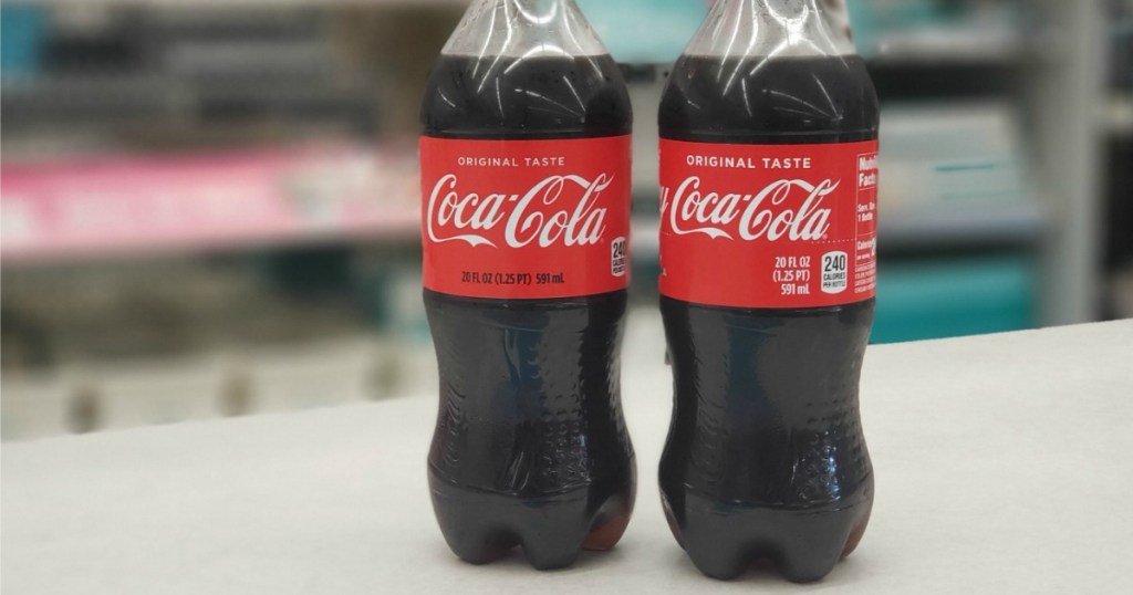 two coca-cola plastic bottles on counter