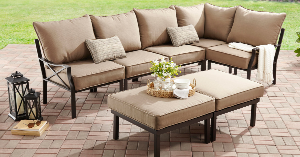 tan outdoor sectional sofa with matching table sitting on a brick patio