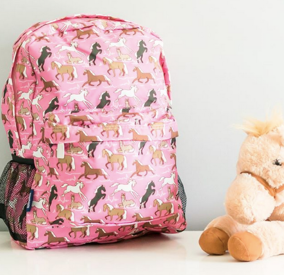 Wildkin Pink Horses Crackerjack Backpack on table with stuffed horse