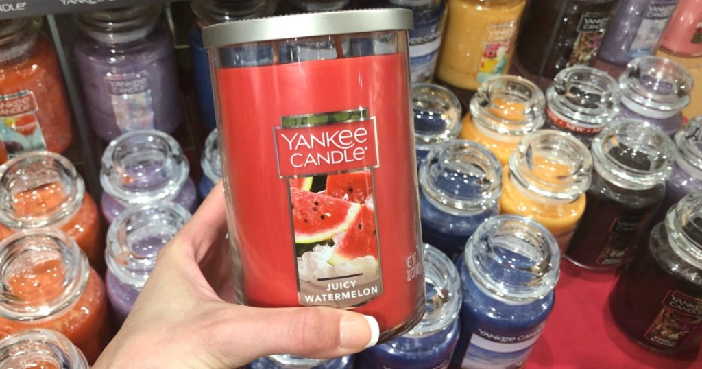woman holding a watermelon Yankee Candle in front of other candles