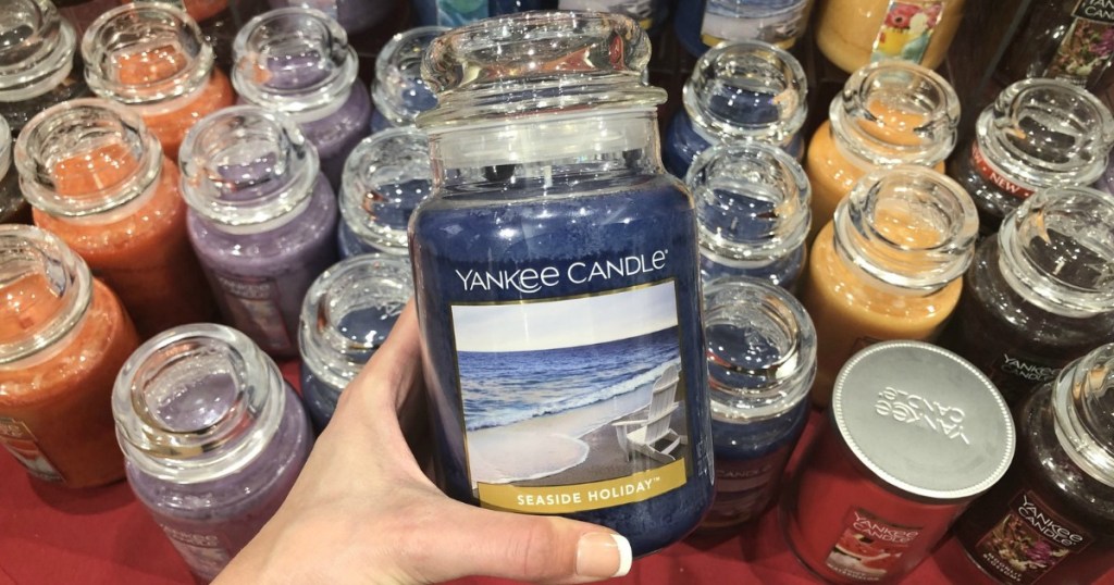 blue candle with an ocean on the label is being held by a woman's hand in Yankee Candle