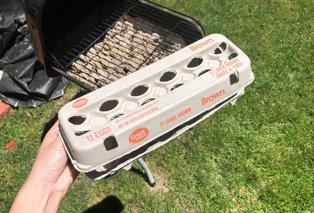 cardboard carton of eggs in front of grill