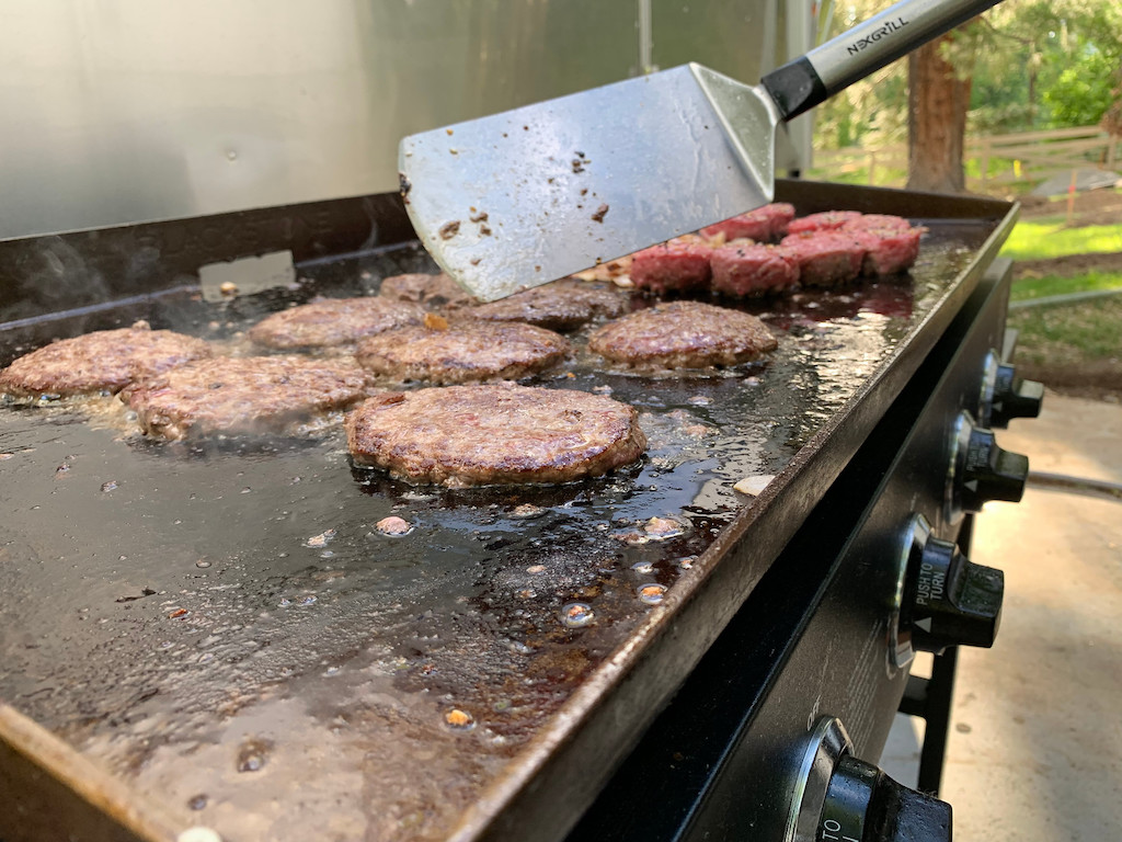 burgers on Blackstone griddle with spatula 