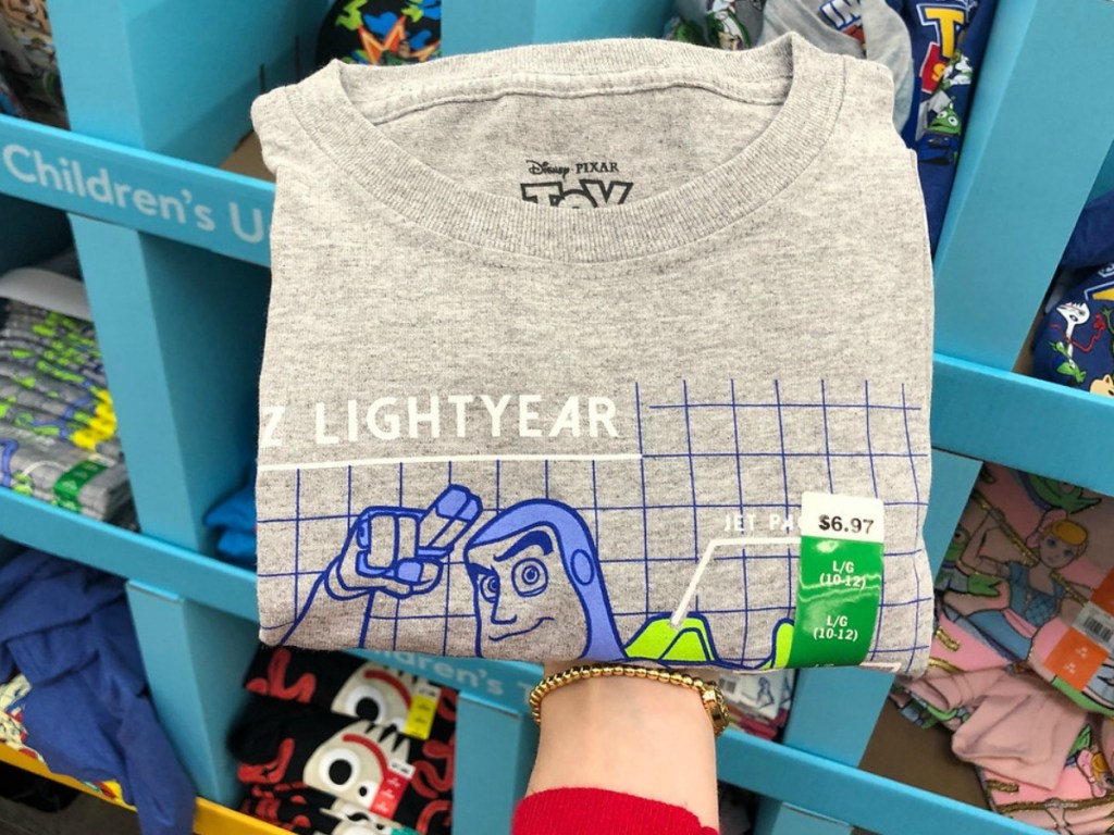 hand holding kids grey shirt by store display