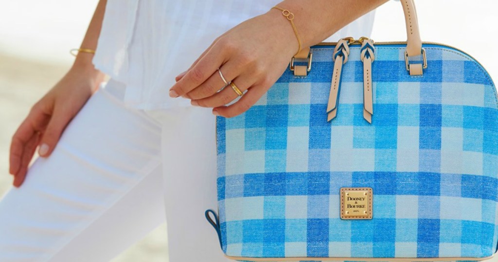 woman holding blue checked purse