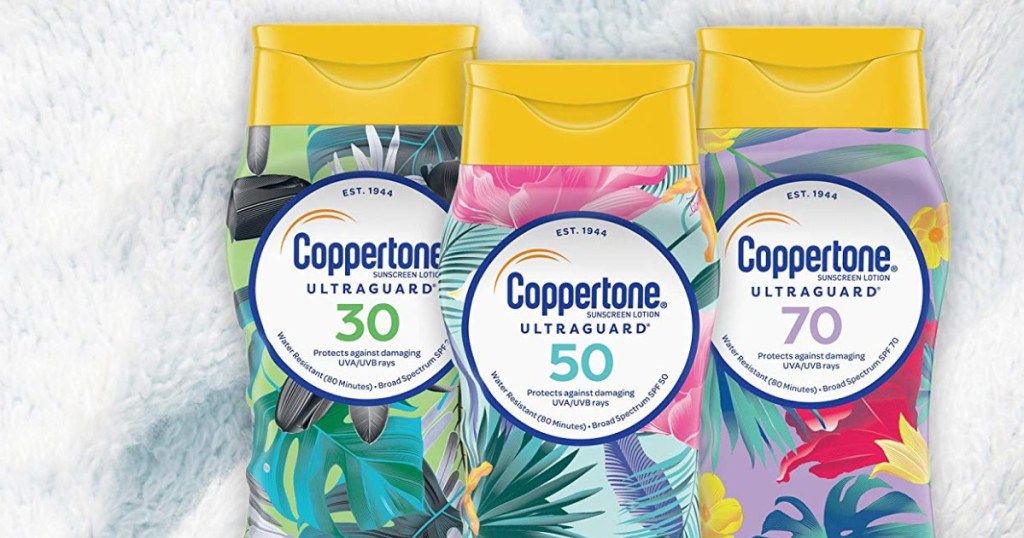 three bottles of coppertone ultraguard sunscreen laying on a towel