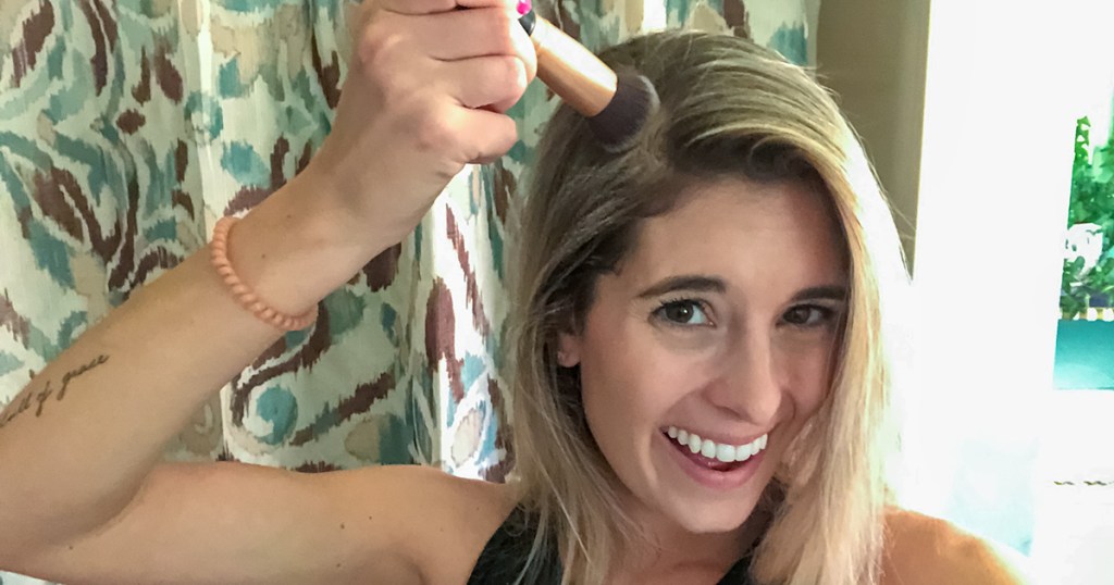 applying dry shampoo with a brush to roots