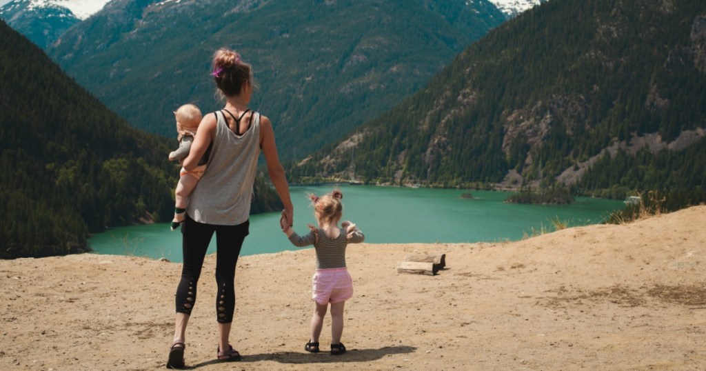 mom with kids at lake surrounded by mountains 