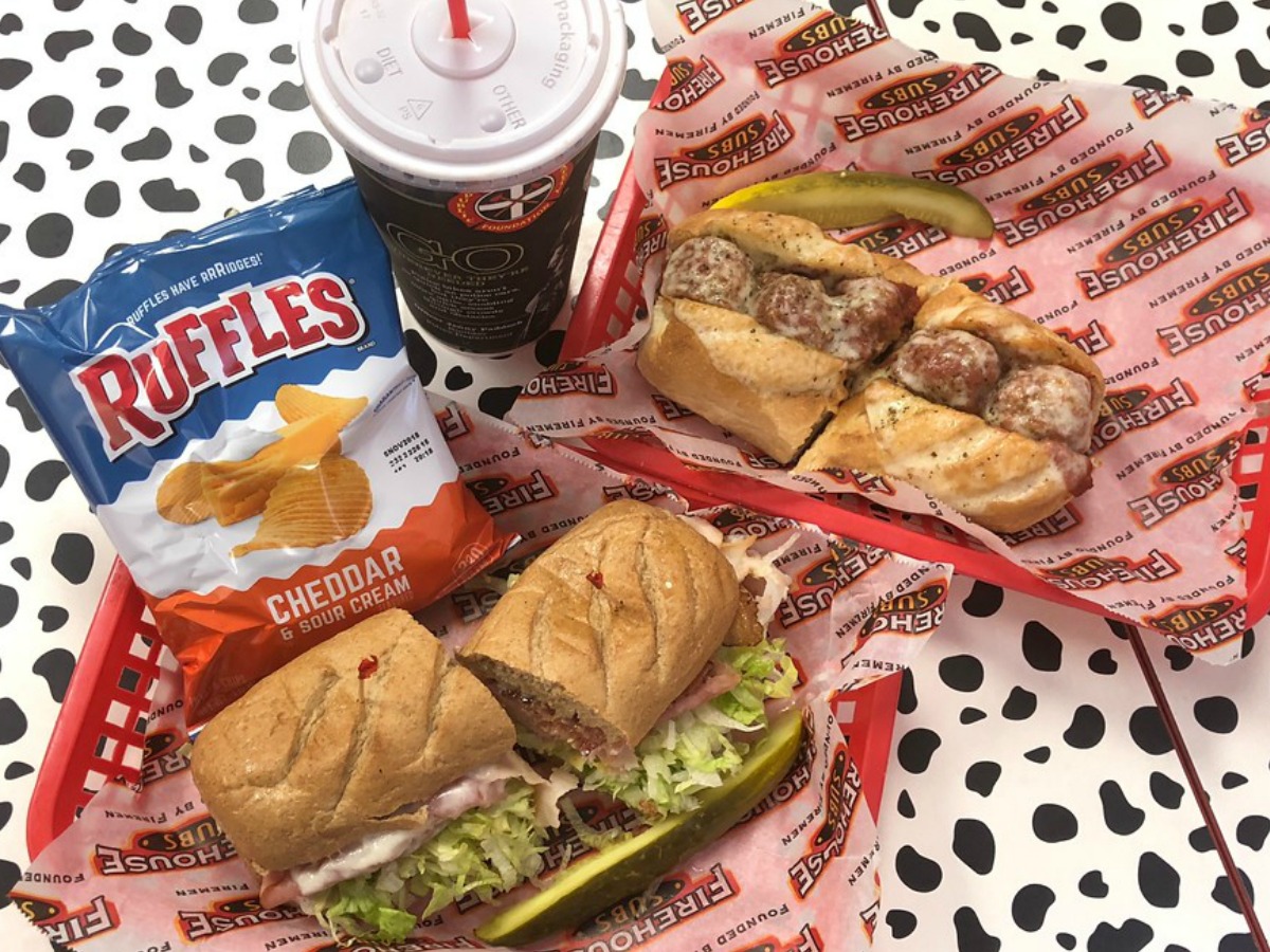 chips, drink and 2 subs on table at Firehouse Subs