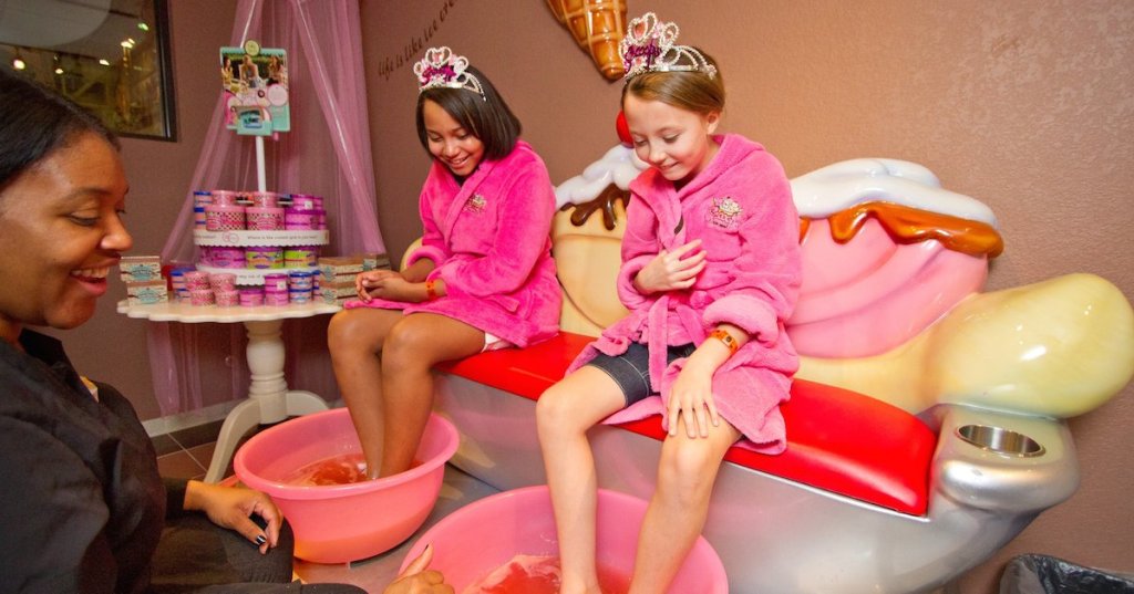 two girls in pink robes having pedicures