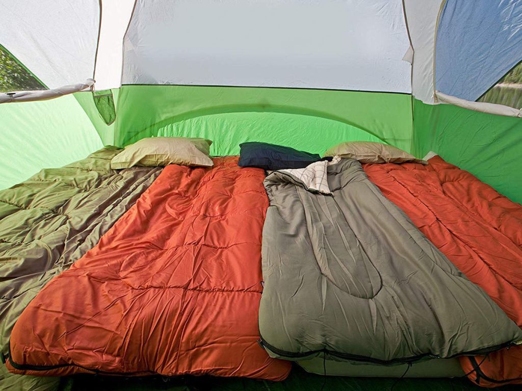 inside of 6 person coleman ten with orange, green, and olive colored sleeping bags