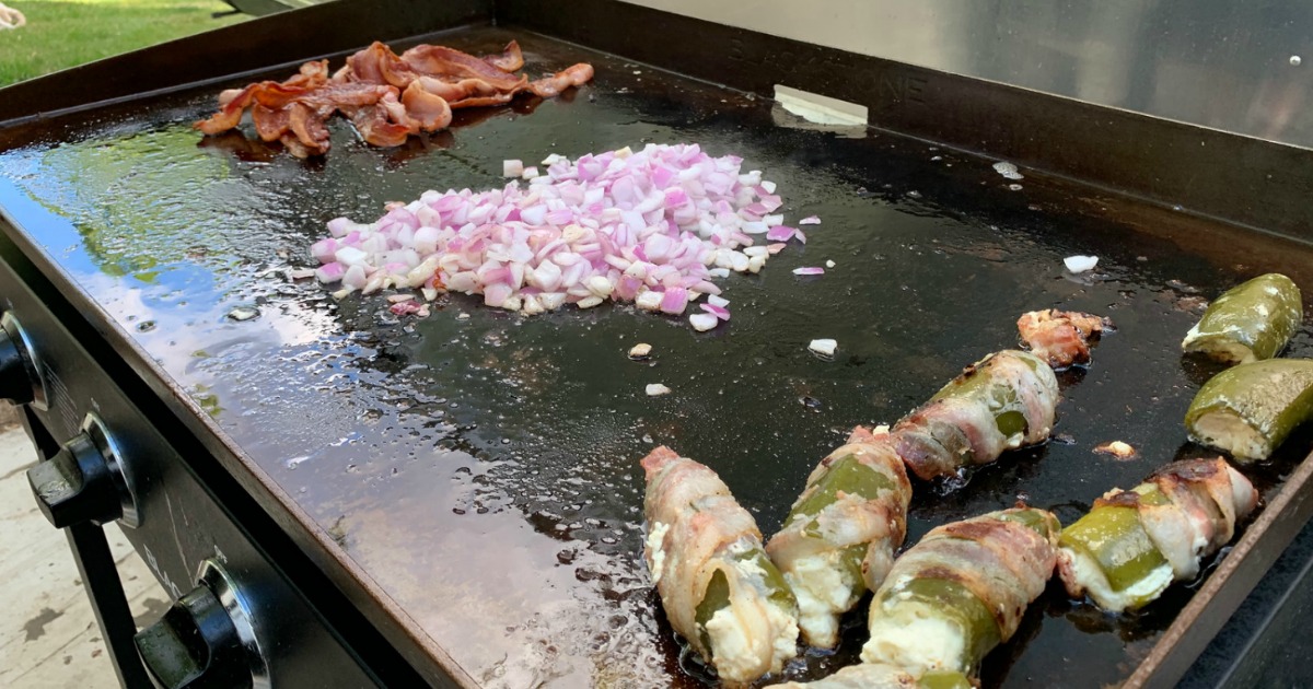 bacon, diced eggs, and jalapeno poppers being cooked on a blackstone griddle