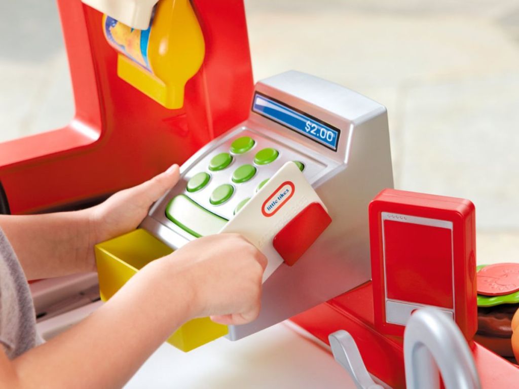 child swiping debit card on little tikes food truck