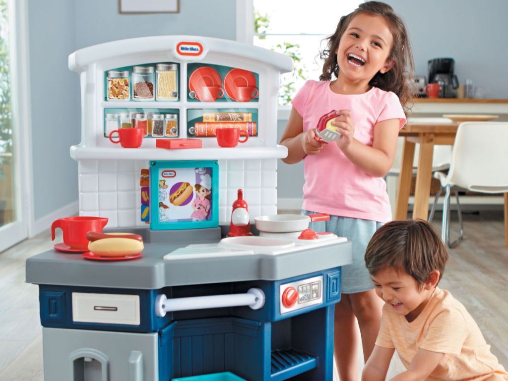 boy and girl playing with little tikes kitchen set in house