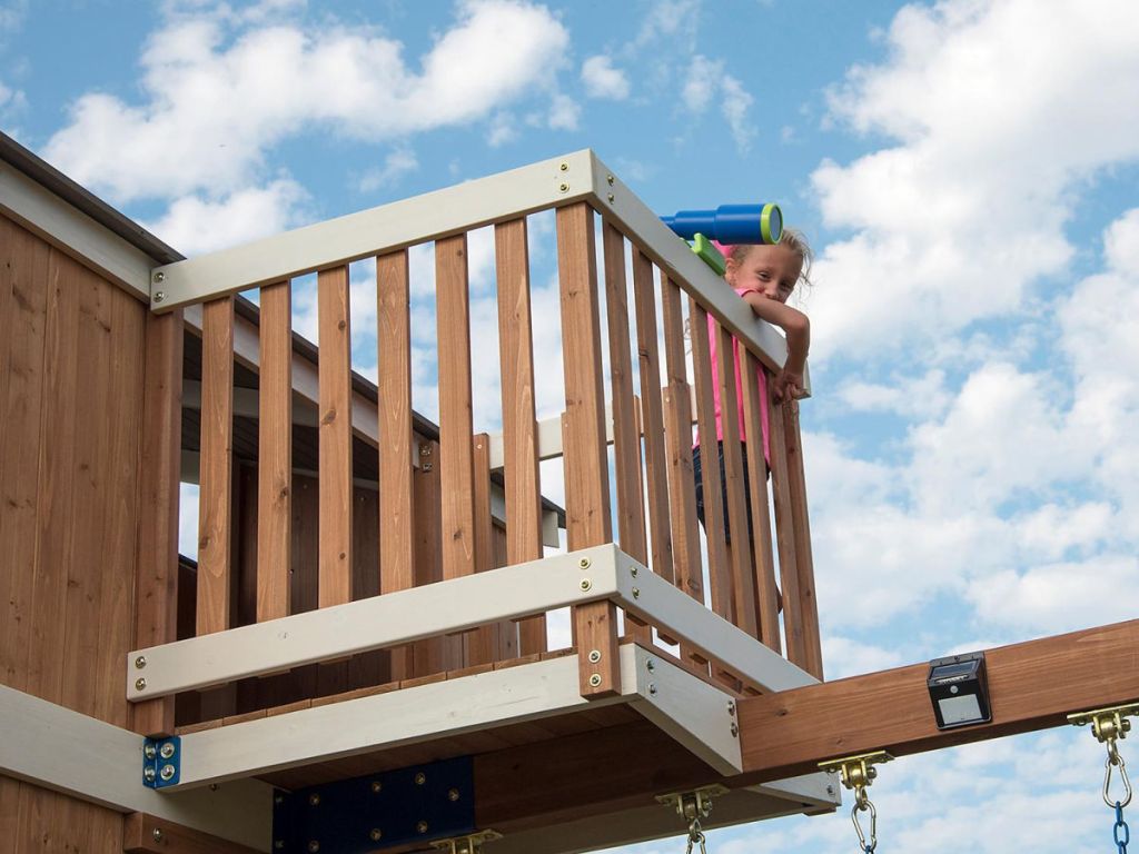 girl on lookout tower of play set with telescope