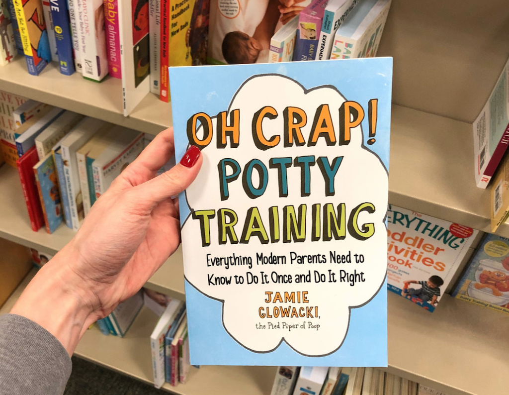 holding Oh Crap! Potty Training Book with potty training tips