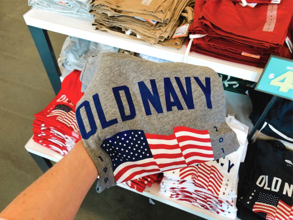 womans hand holding grey old navy flag shirt in store