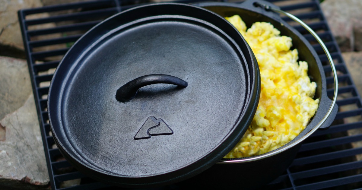 cast iron dutch oven with lid slightly open displaying scrambled eggs