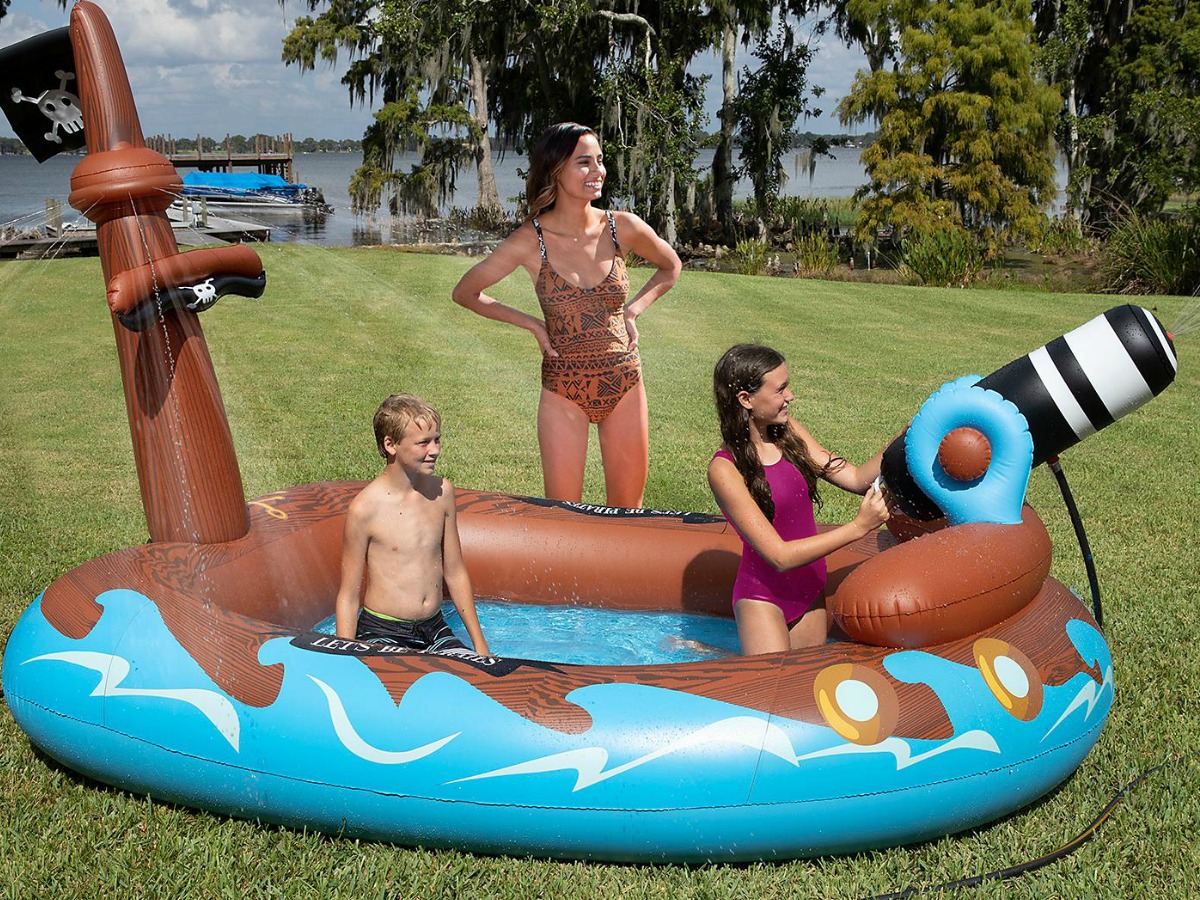 kids playing in pirate ship portable pool boat with woman watching