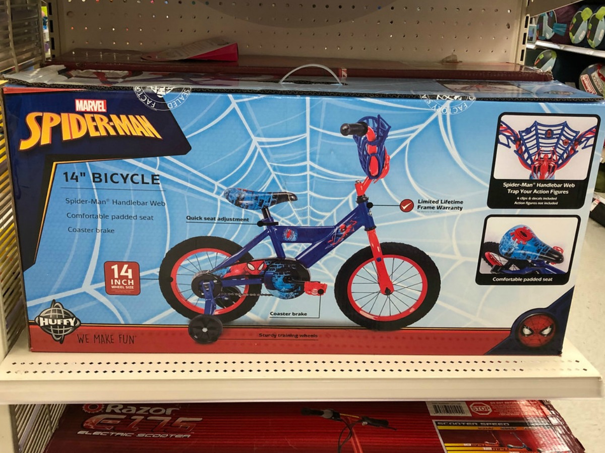 box with small spiderman decorated bike in it on store shelf